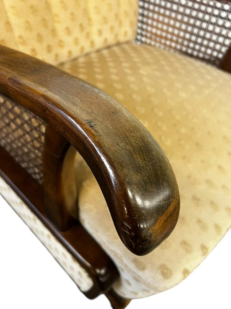 Vintage wooden armchair with rattan weaving.