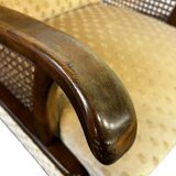 Vintage wooden armchair with rattan weaving.