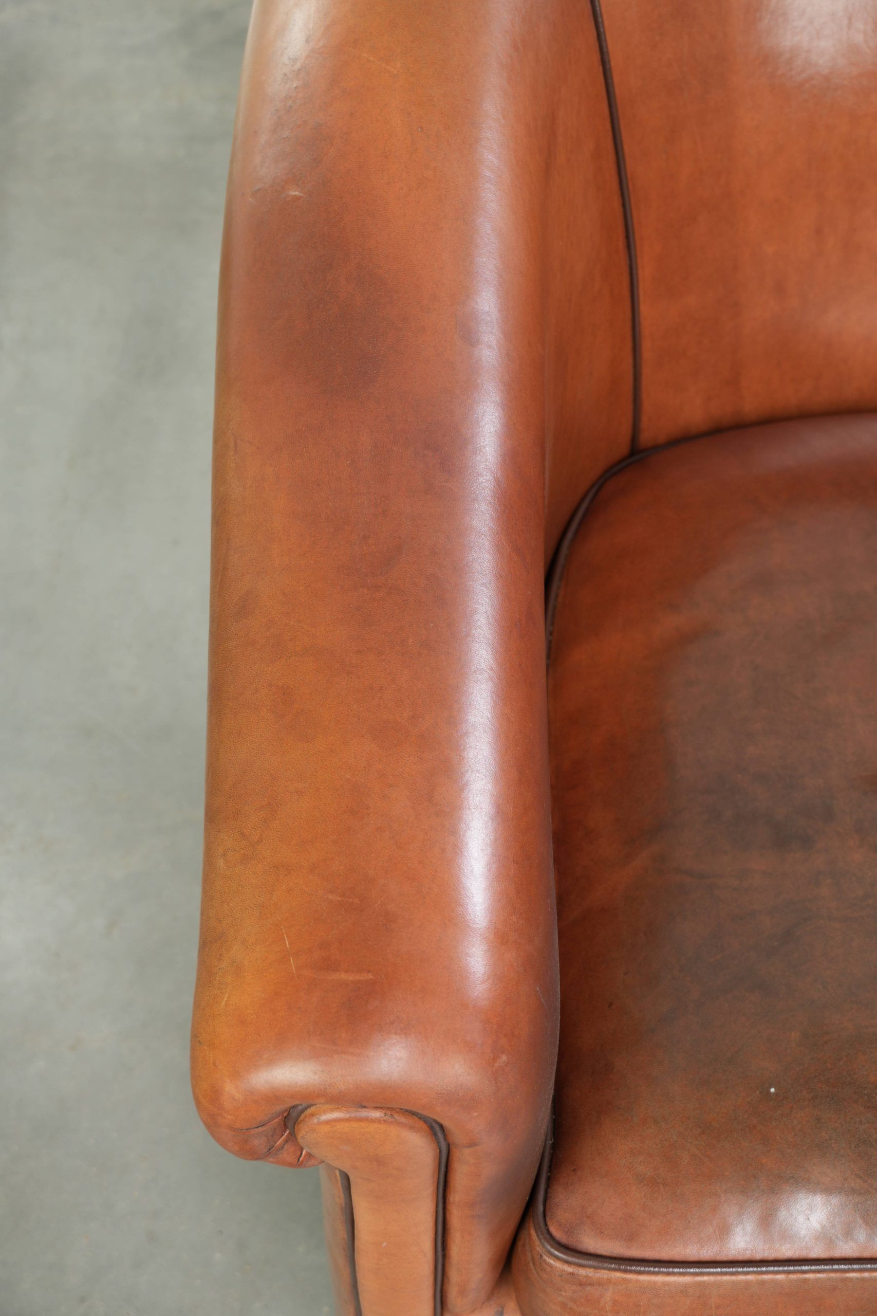 Vintage sheepskin club armchair with a warm colour scheme with black piping