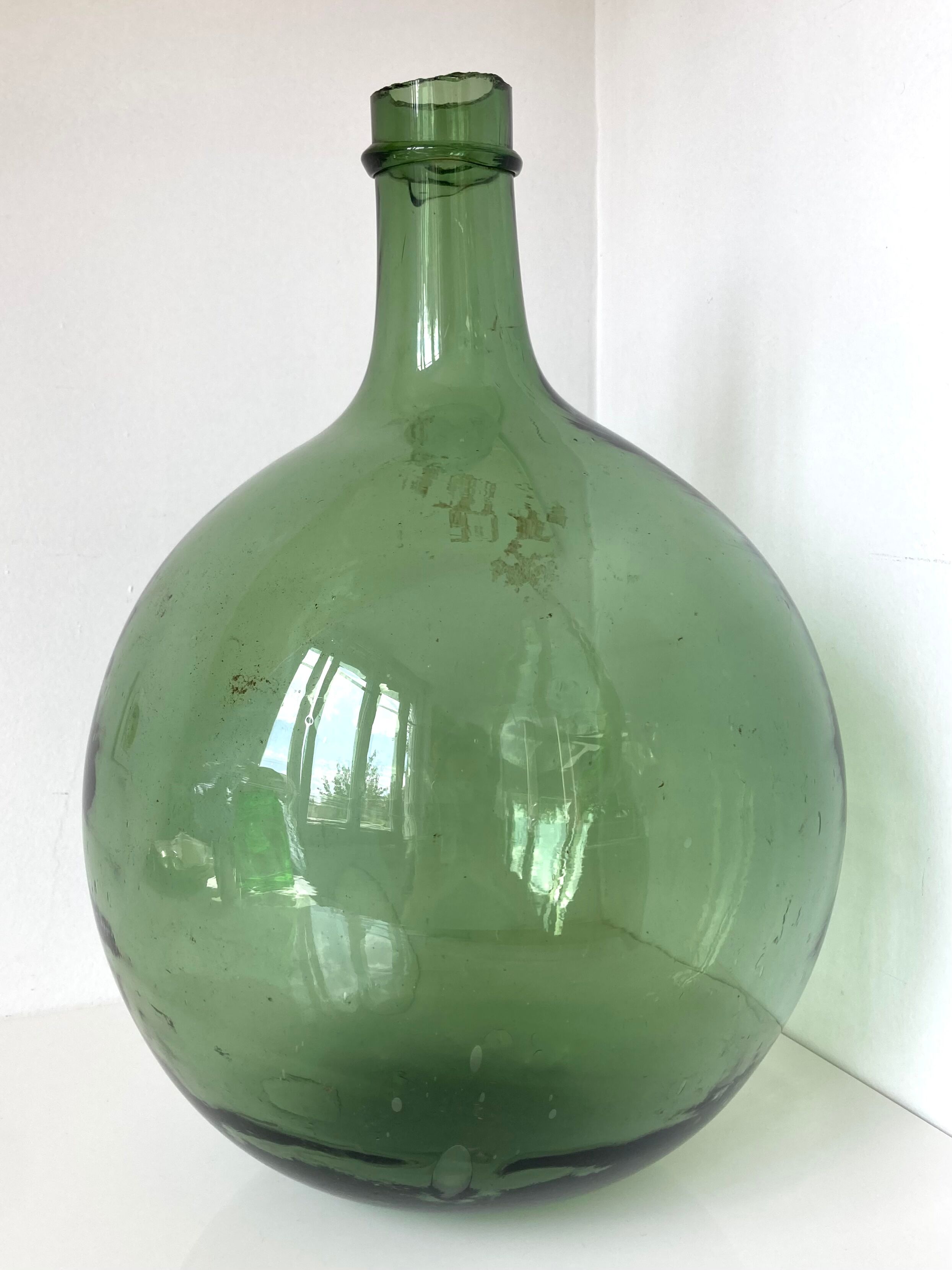 Old demijohn in green glass with ringed neck and hammered opening
