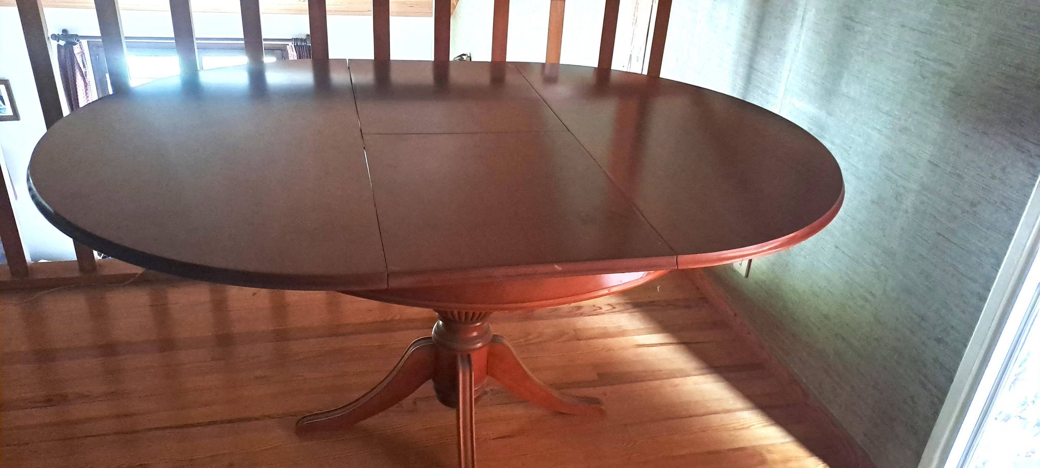 Round solid walnut table with central leg from the 1950s with extensions.