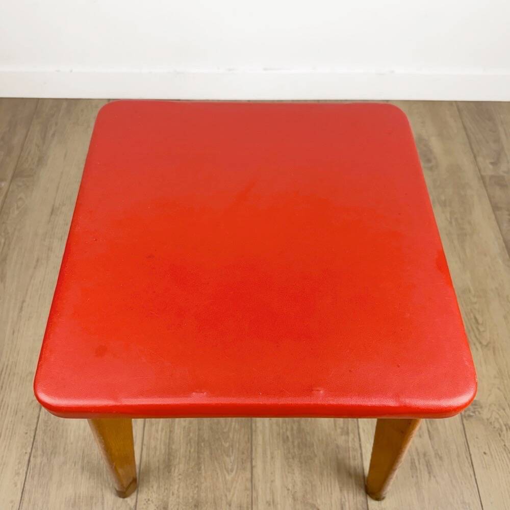 Wooden stool with red faux leather from the 1950s.