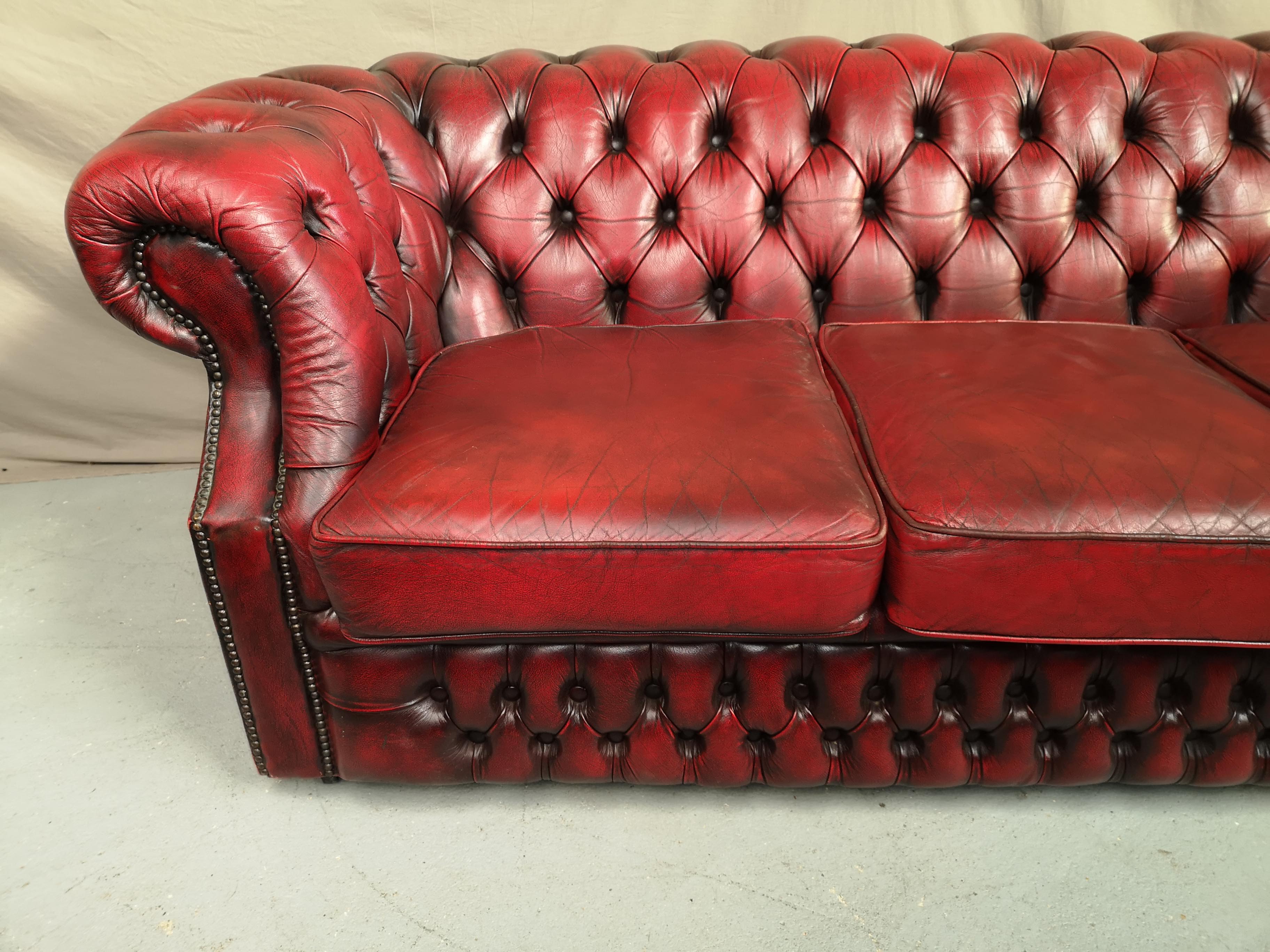 Three-seater curved red leather chesterfield sofa