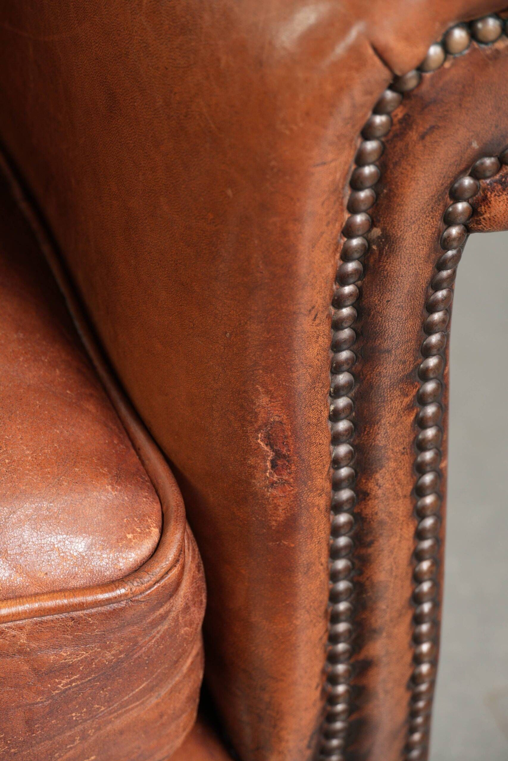 Comfortable vintage sheepskin armchair finished with decorative nails
