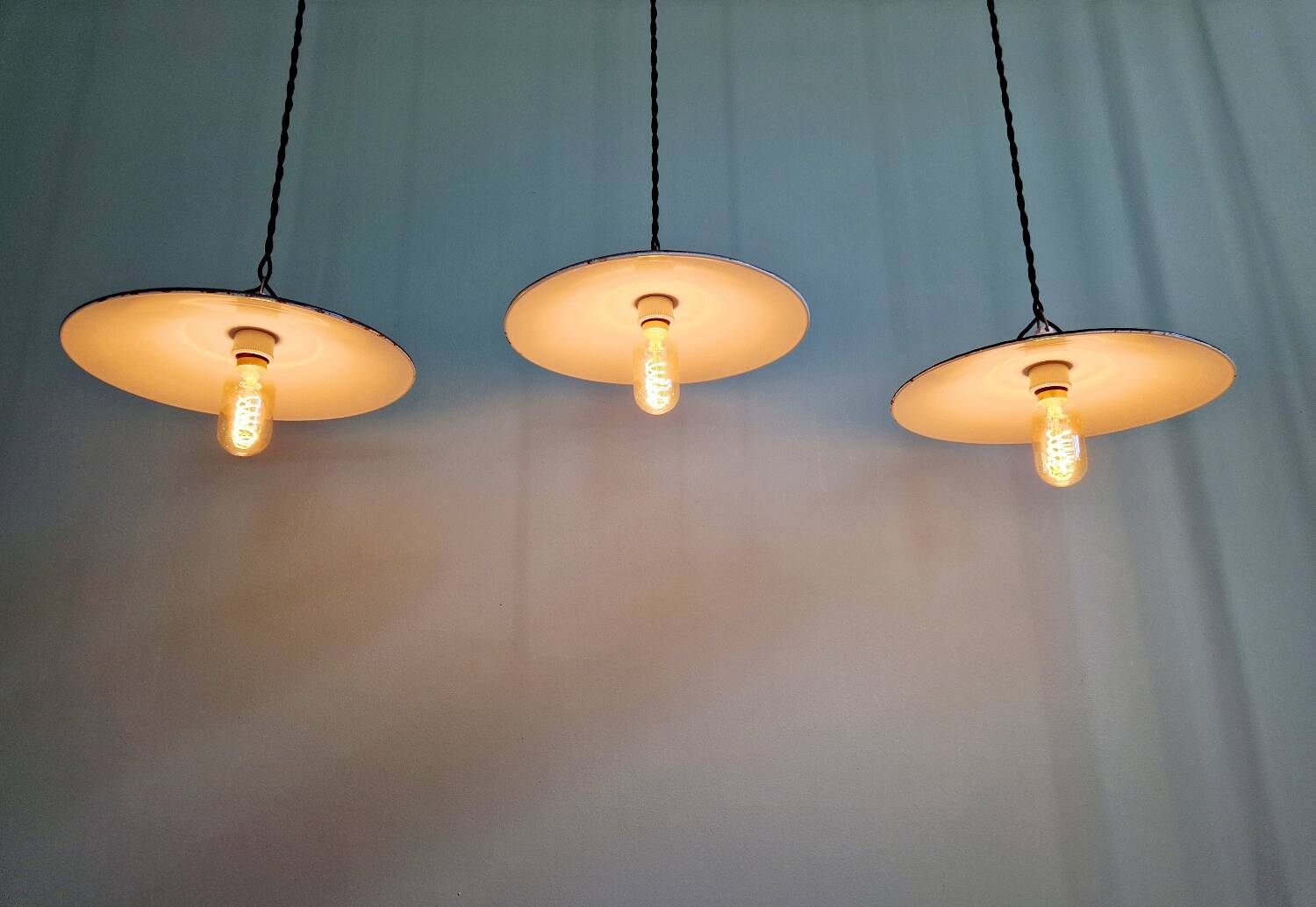 Three industrial suspensions in black enamelled sheet metal.