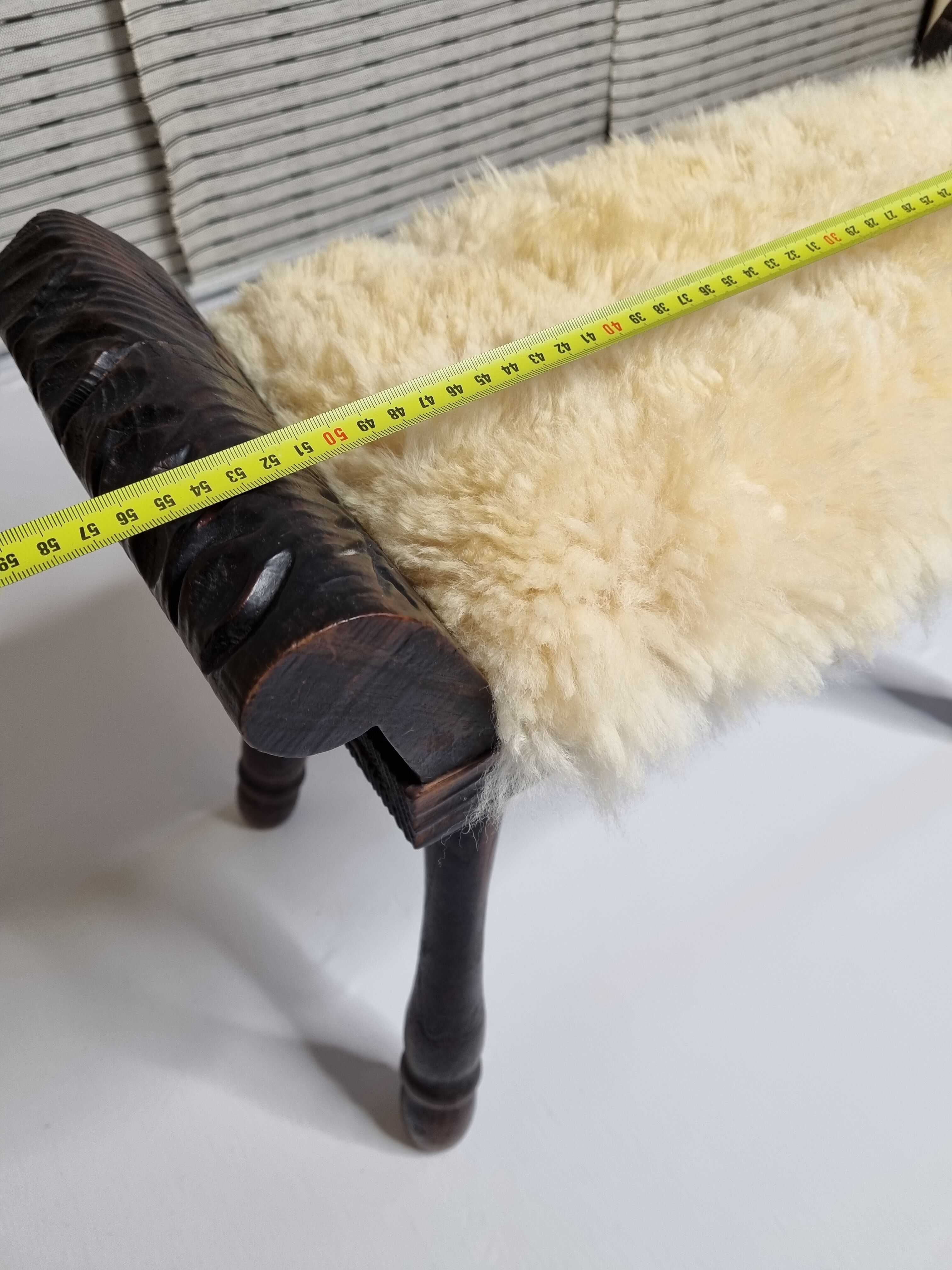 Carved wooden stool covered with Celtic-style sheepskin