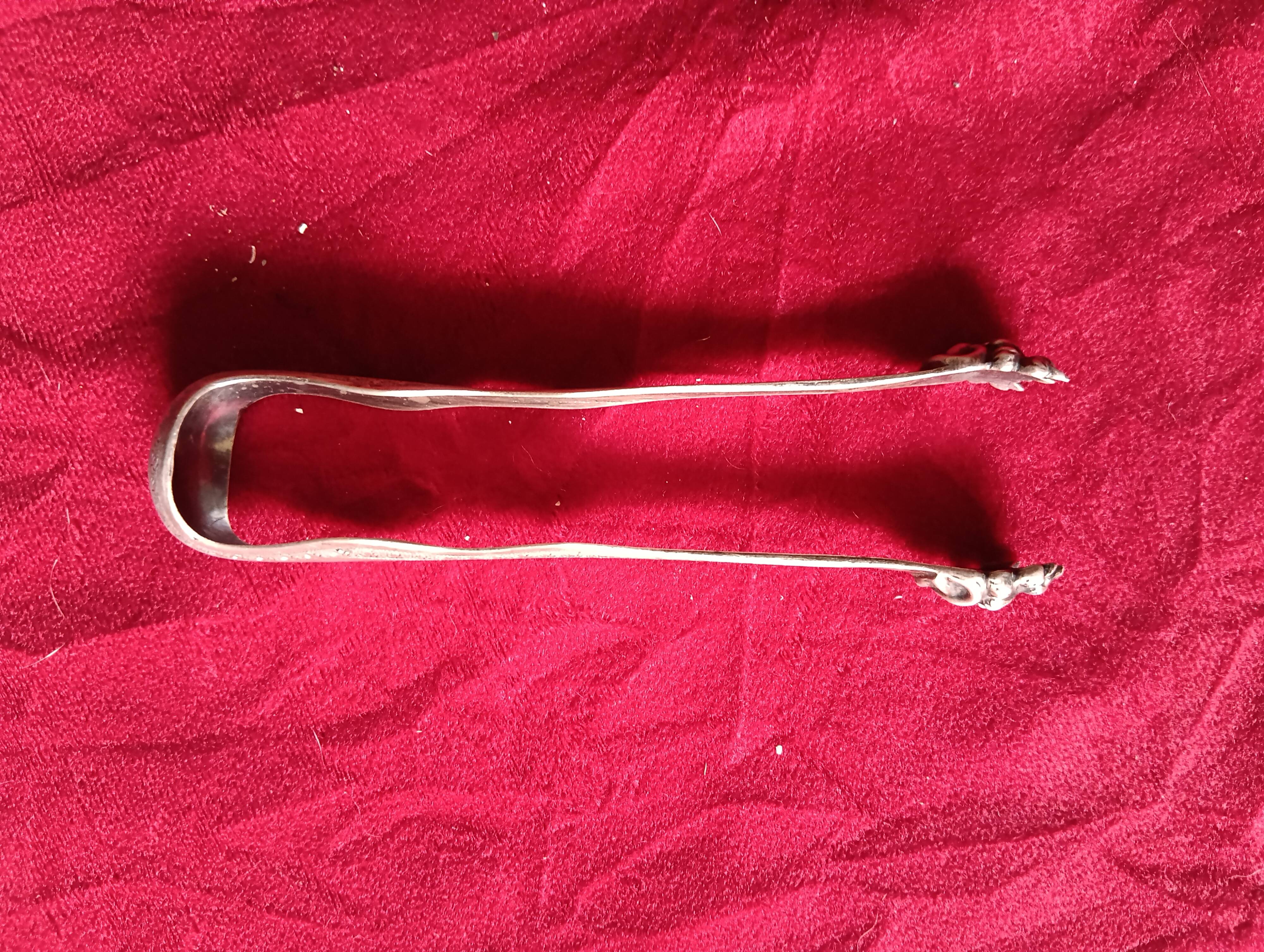 Silver sugar tongs with engraved decoration and lion claws.