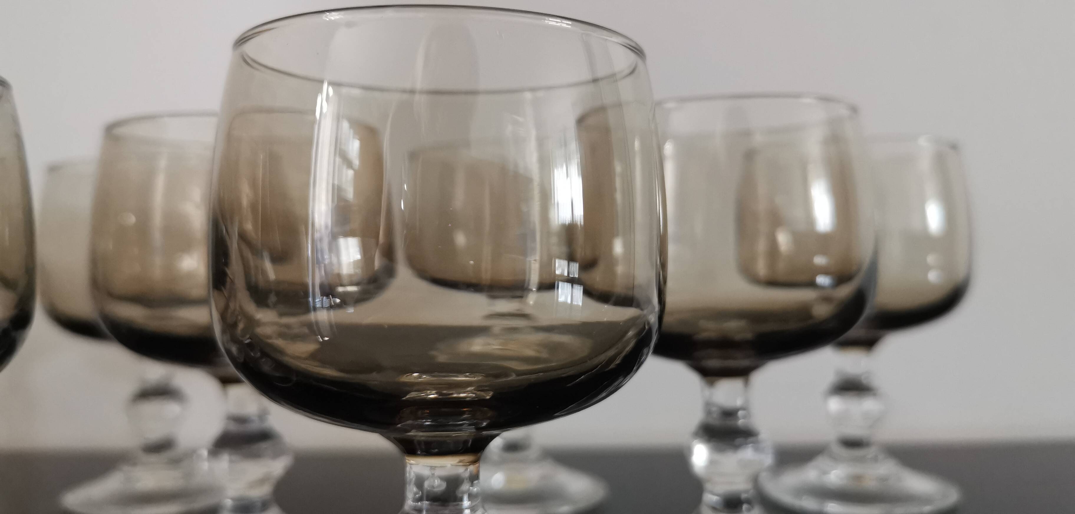 9 white wine glasses on vintage Luminarc smoked black stem