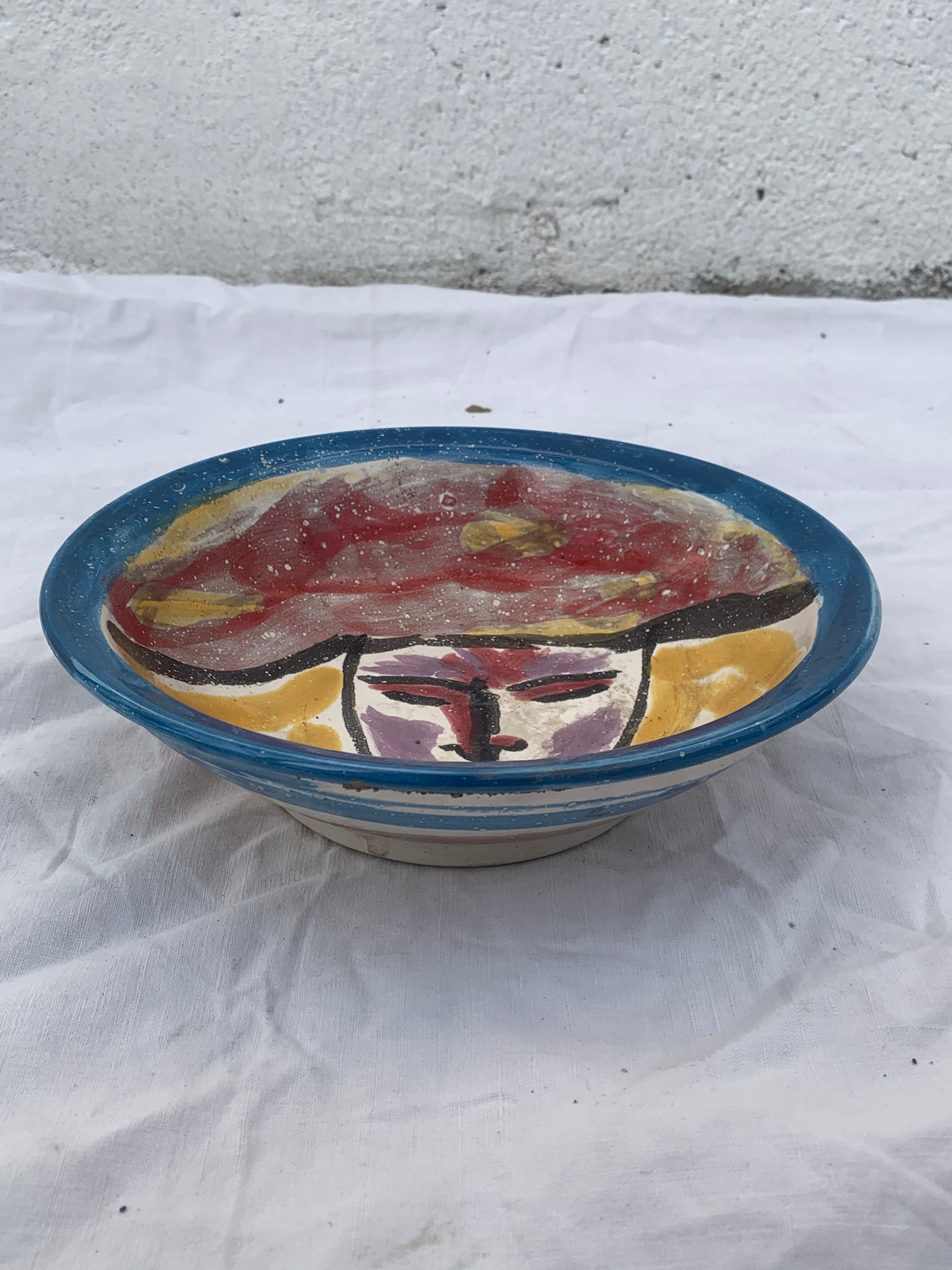 Hand-painted plate decorated with a colorful face 60s