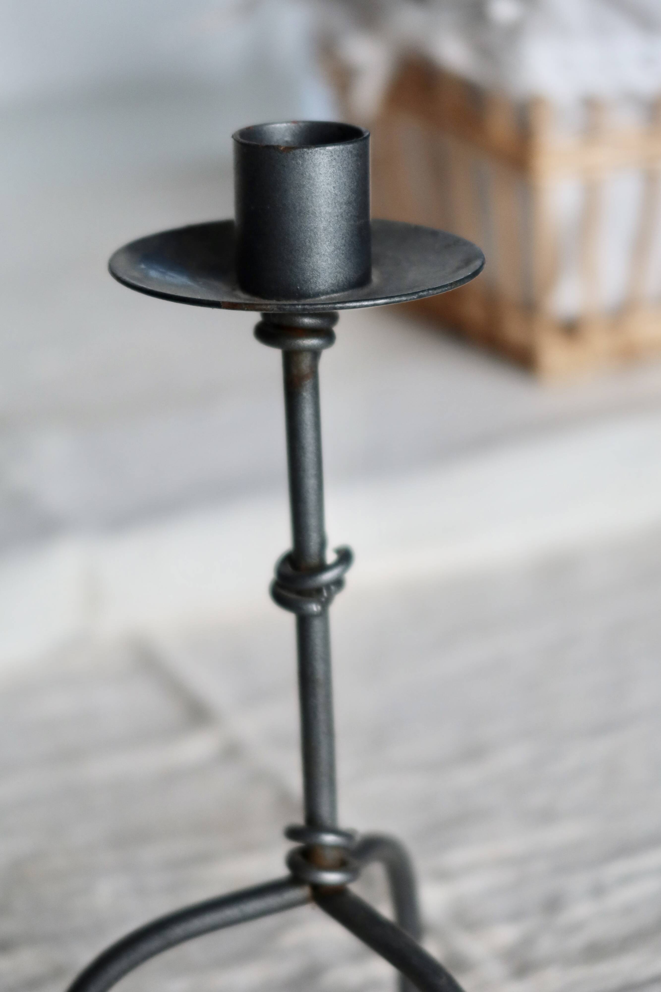 Antique tripod metal candlestick with knot decoration