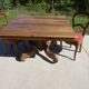 Old walnut table with a central leg.