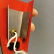 Danish red lacquered wall light with brass details. Estimated 1980s