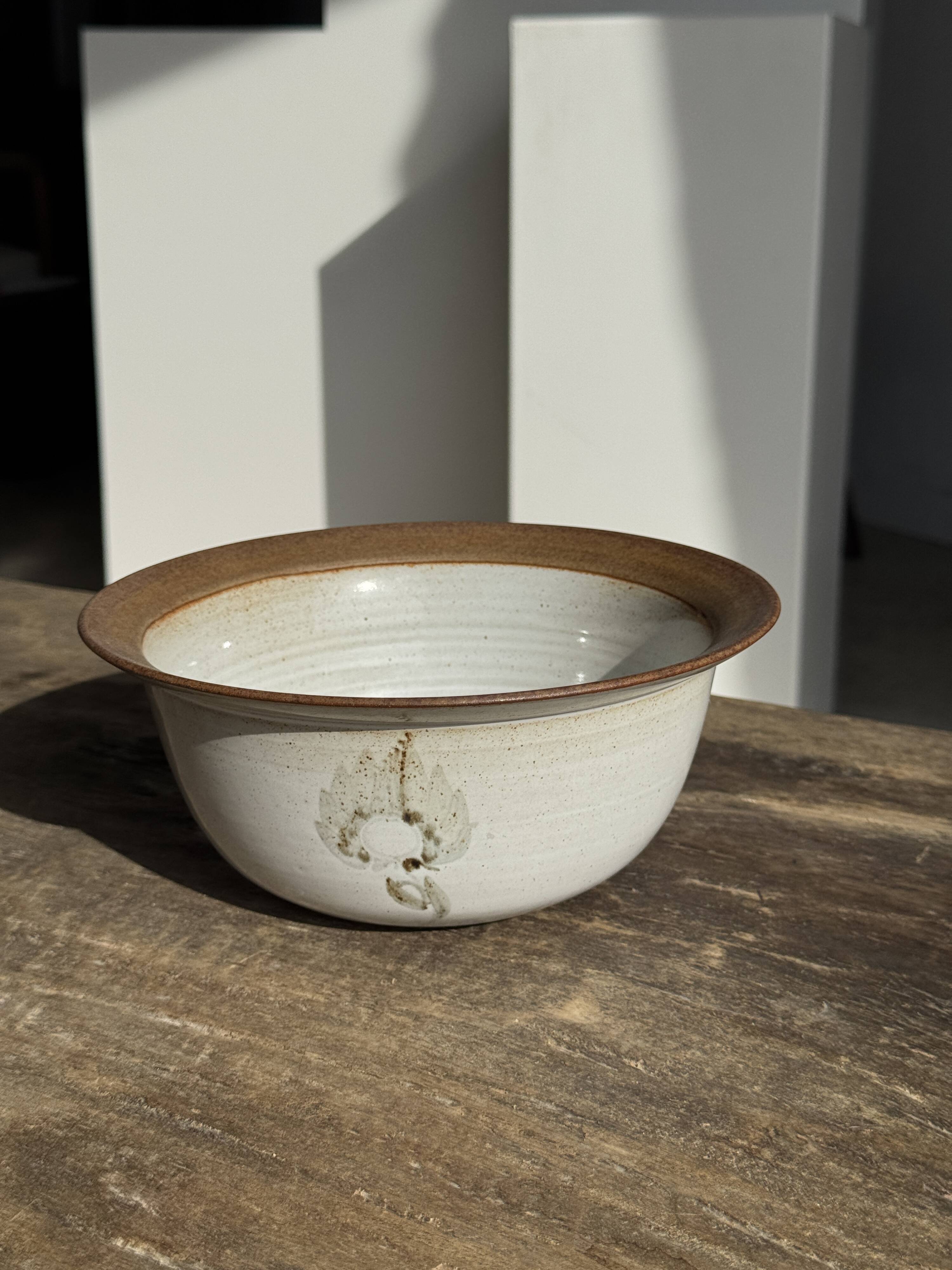 Small thick stoneware bowl with a stylised flower pattern in white on the outside, b
