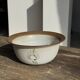 Small thick stoneware bowl with a stylised flower pattern in white on the outside, b