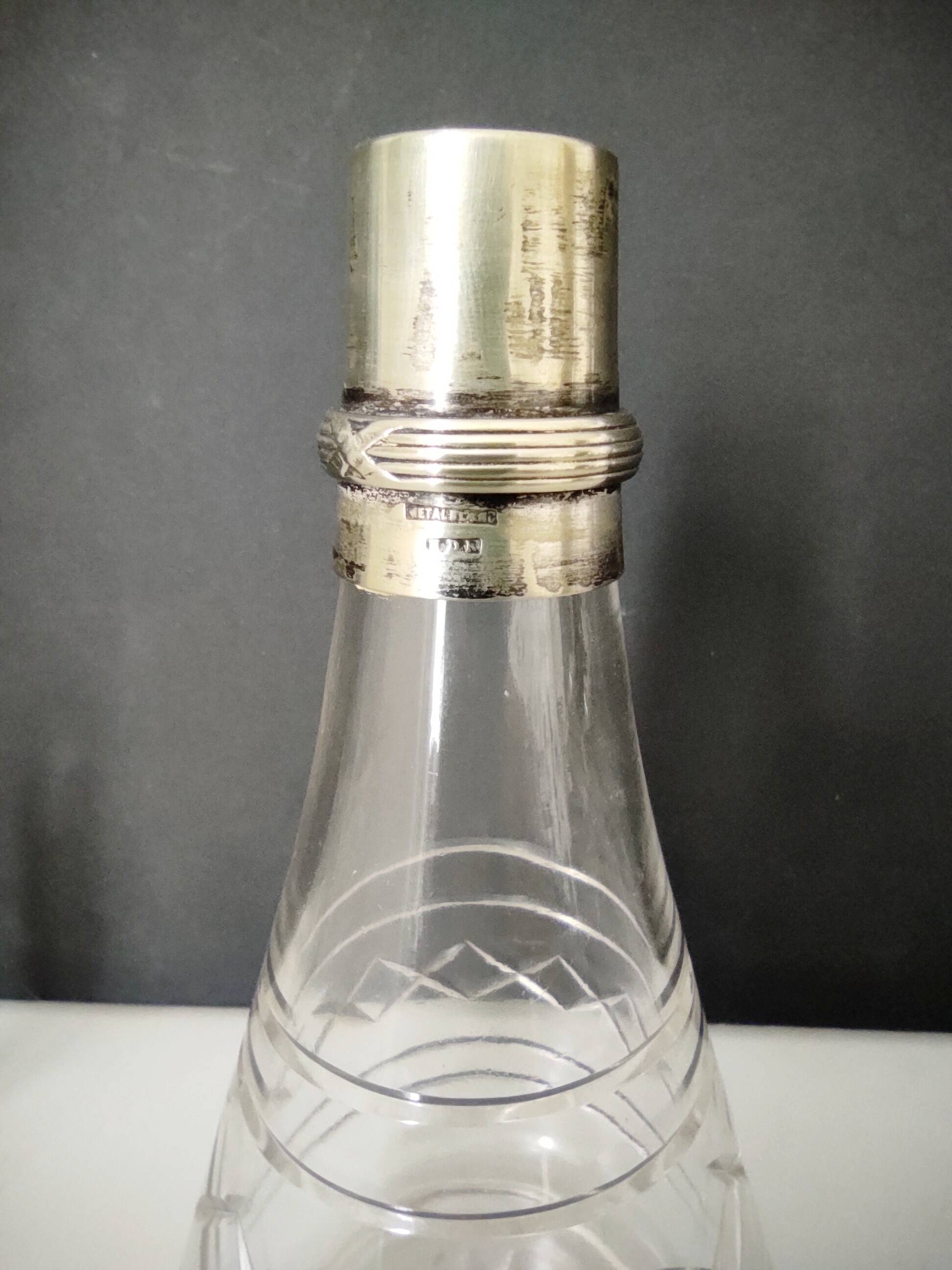 Crystal bottle with silver metal neck rim
