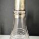 Crystal bottle with silver metal neck rim