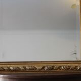 Miroir ancien doré surmonté d'un fronton et glace biseautée
