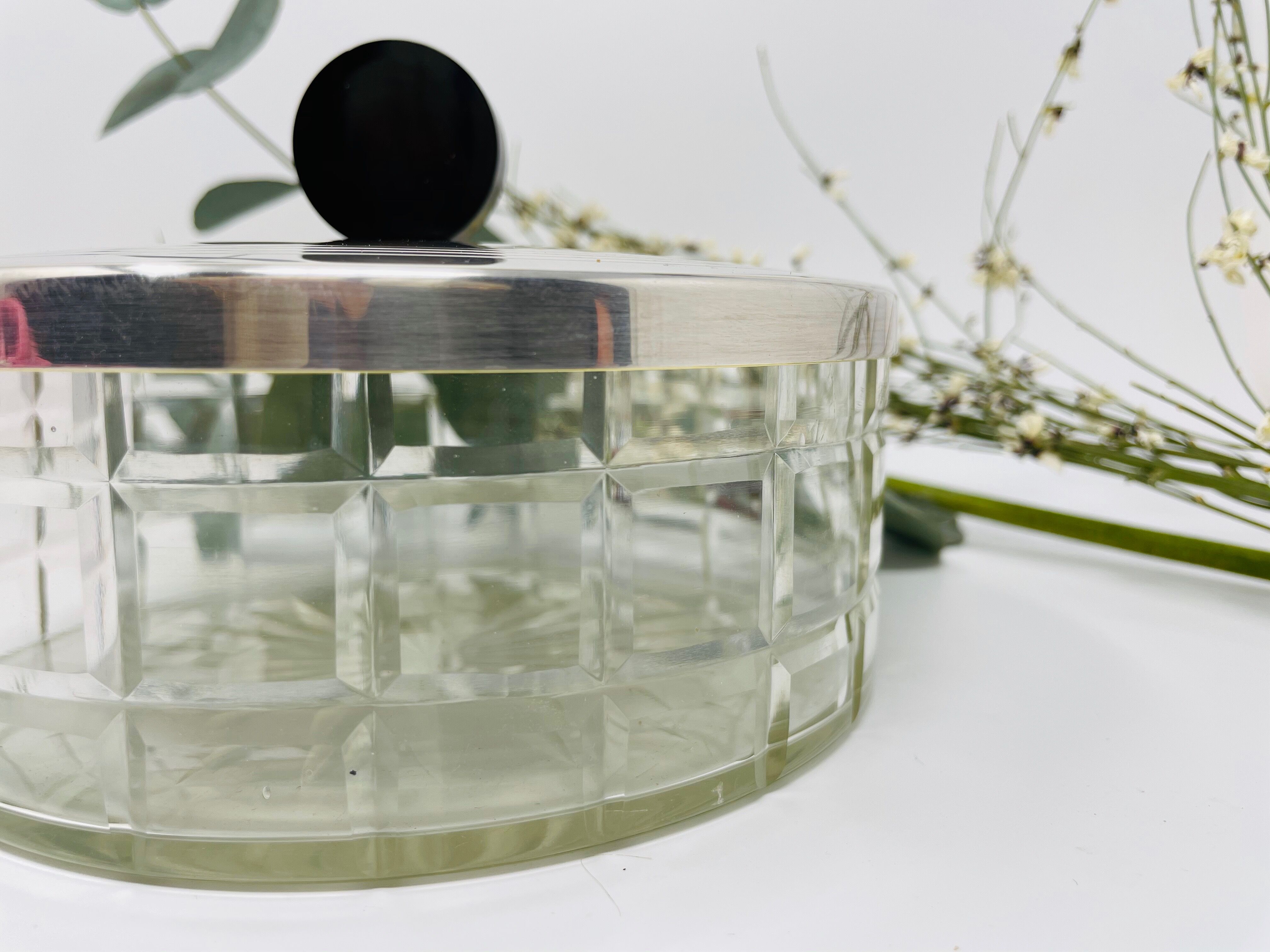 Vintage box made of chiseled glass and covered metal, taken in black Bakelite