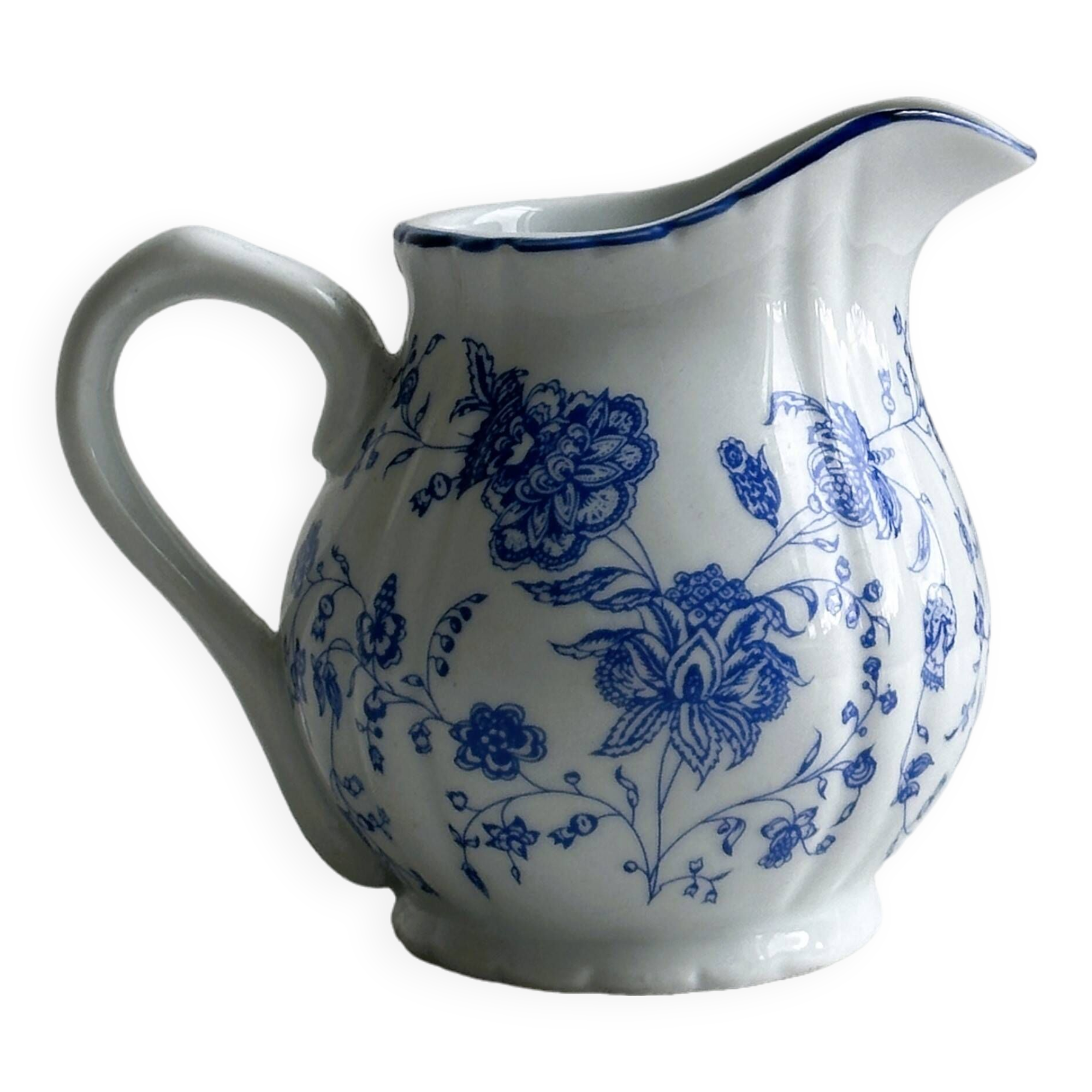 White porcelain milk jug with blue floral designs.