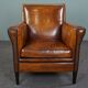 Art deco armchair in sheepskin with black piping and decorative nails
