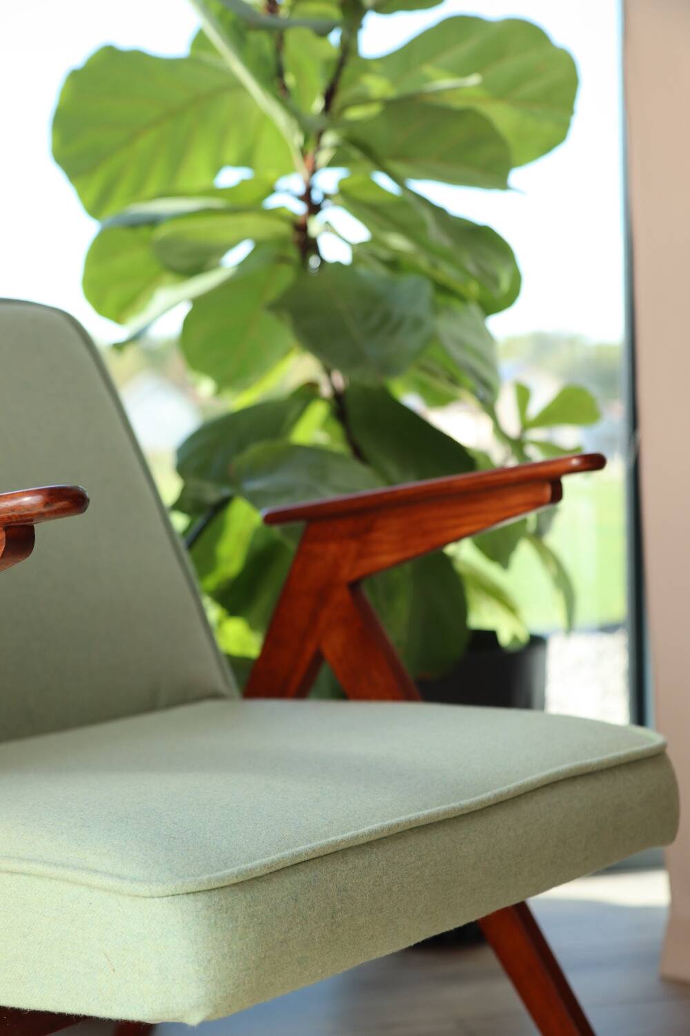 Vintage armchair in mint green wool, mid-century modern design.