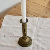 Antique brass candlestick with a push button.