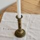 Antique brass candlestick with a push button.