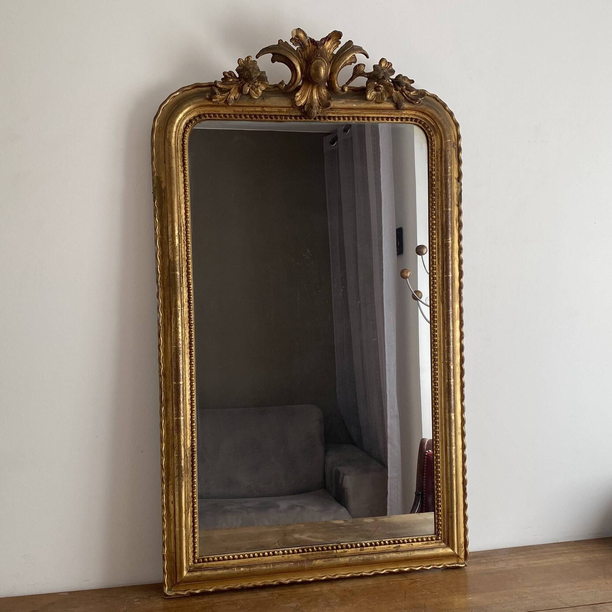 Golden mirror from the late 19th century with a decorated pediment. 130x74.