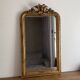 Golden mirror from the late 19th century with a decorated pediment. 130x74.