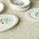 Tableware set in earthenware with floral decoration.