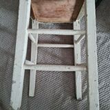 Vintage wooden stool with white peeling paint
