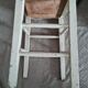 Vintage wooden stool with white peeling paint