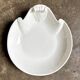 Small, shallow porcelain dish shaped like a seashell