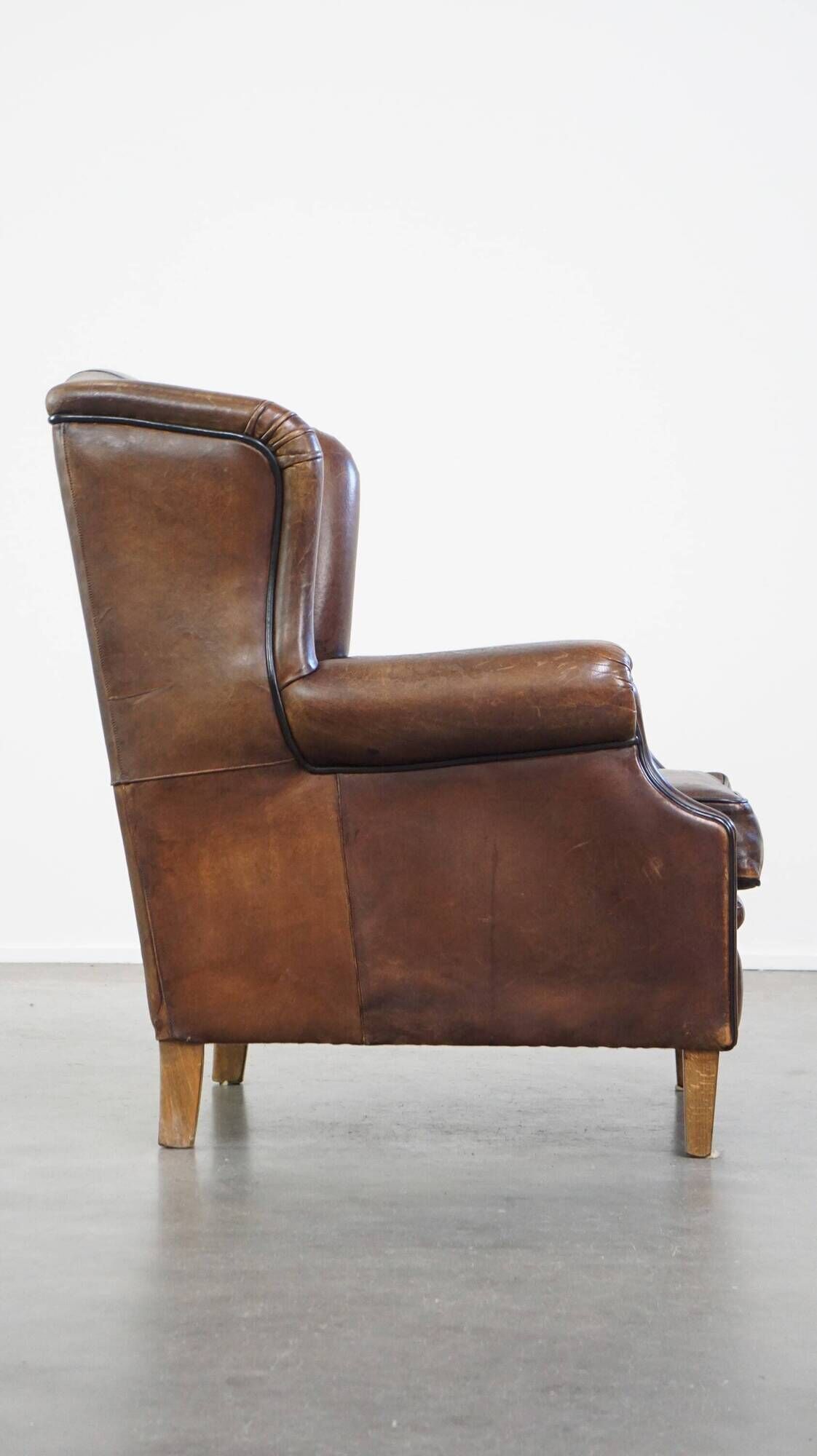 Wing chair made of sheepskin and neatly finished with black piping