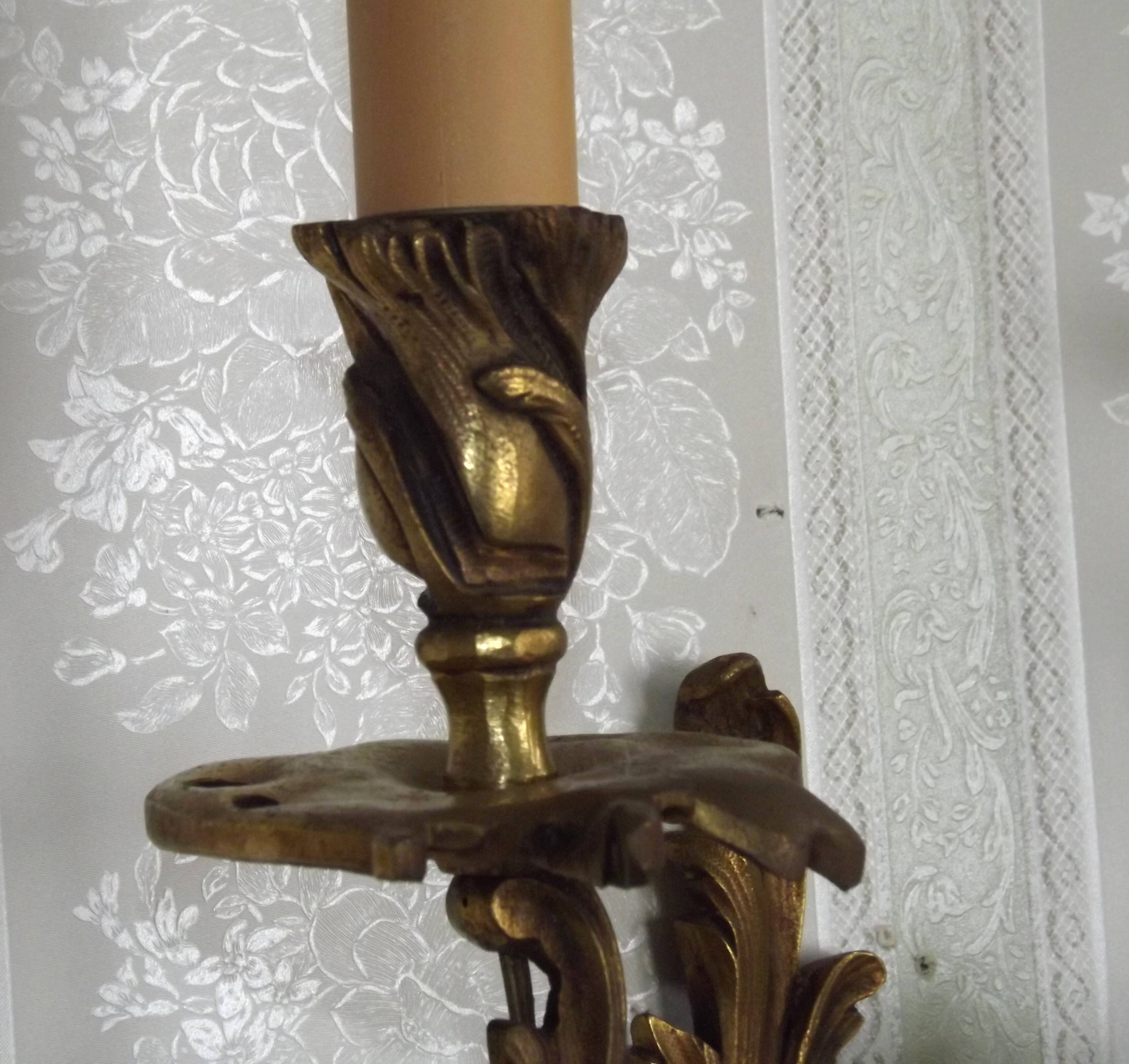 Apply two bronze wall lights decorated with acanthus leaves.
