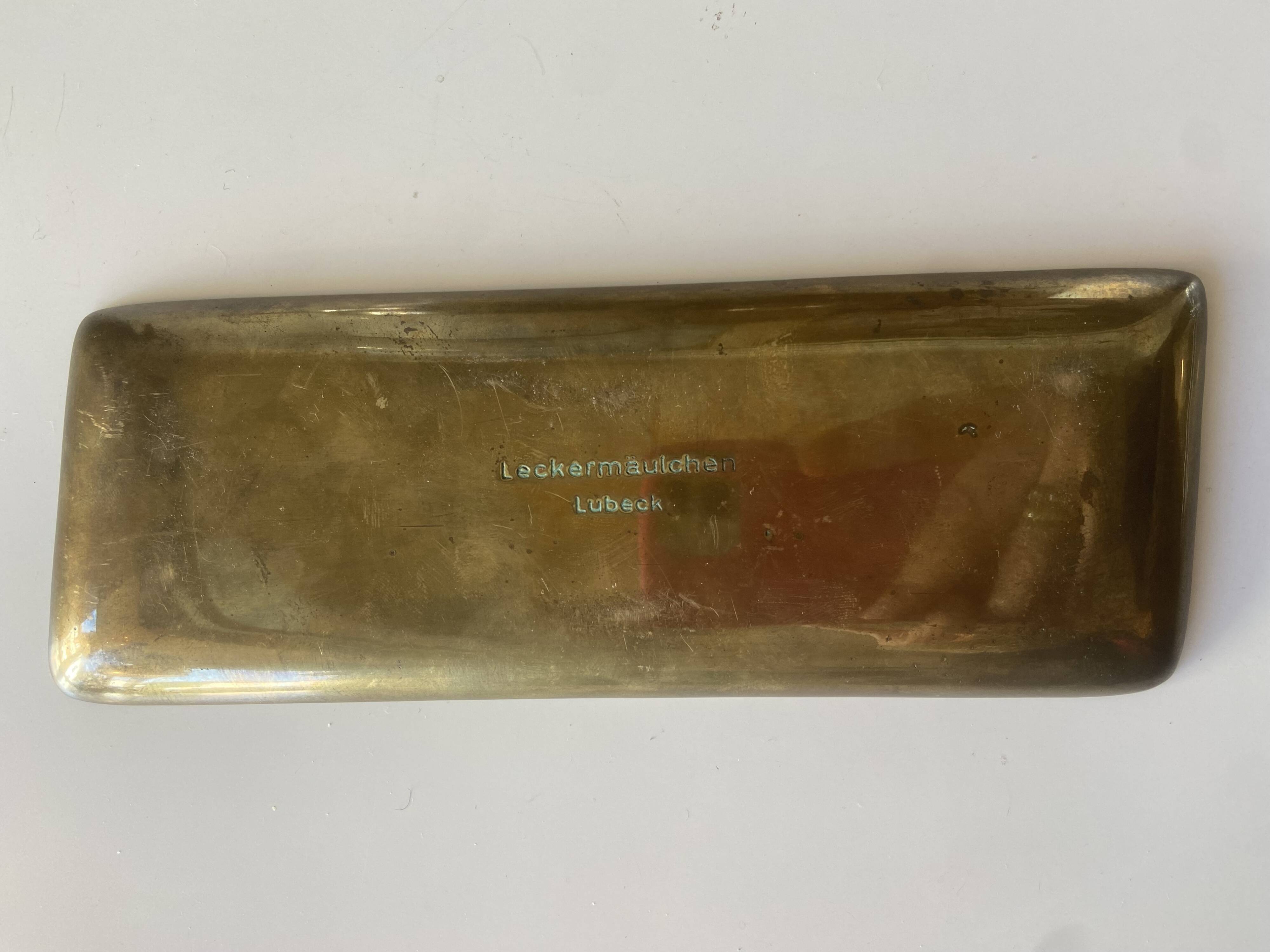 Bronze pocket emptier with fish decoration.