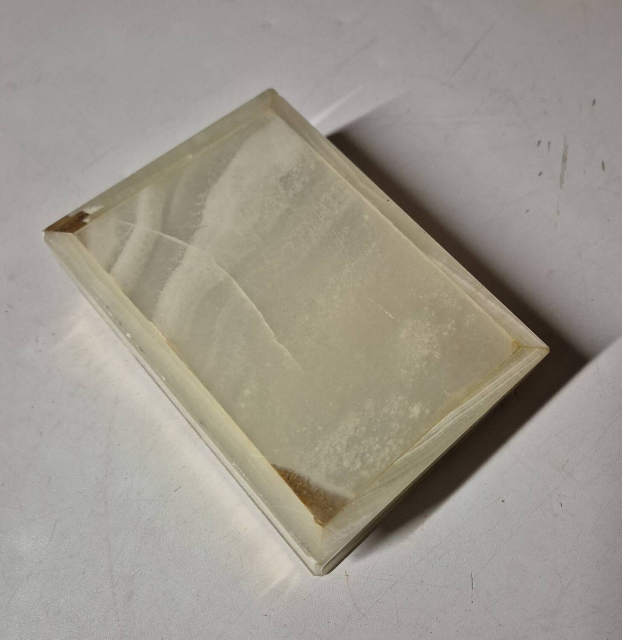 Rectangular light onyx jewellery box with brass trim, empty.