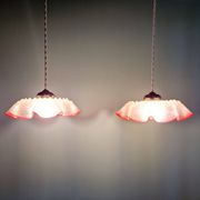 Pair of clear and pink satin glass scalloped pendant lights, 1920s-30s