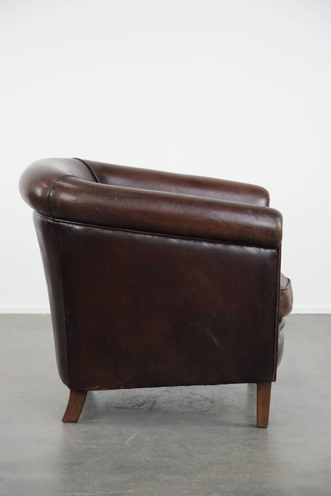 Stylish and sturdy dark brown club armchair made of sheepskin leather