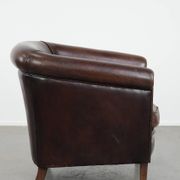 Stylish and sturdy dark brown club armchair made of sheepskin leather