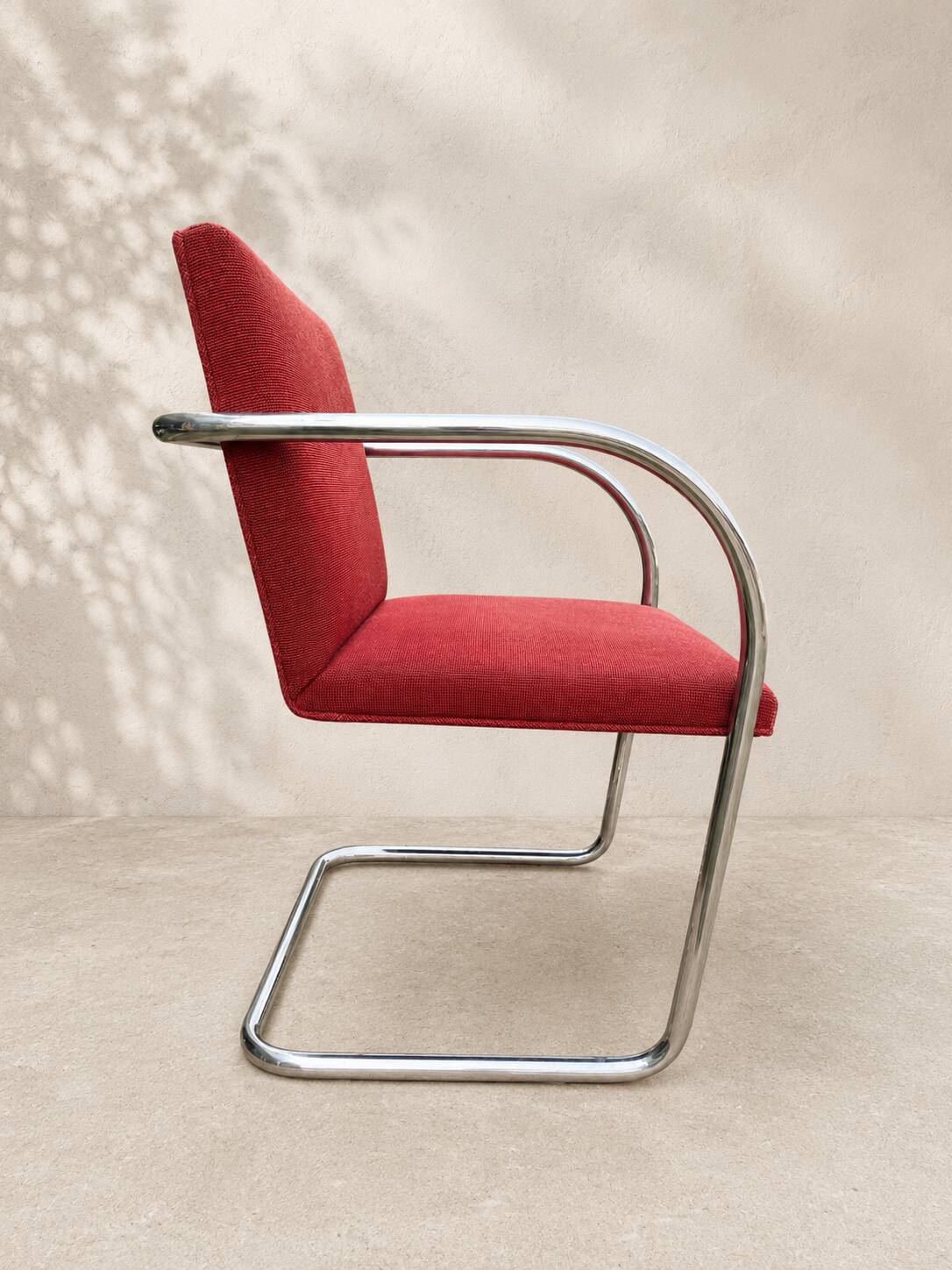 Vintage cantilever chair in chrome and burgundy fabric.