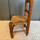 Old, rustic children's chair, small wooden and straw chair.
