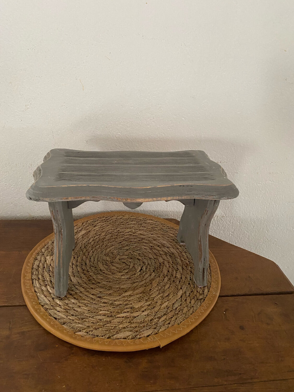 Small footrest bench in solid wood with a slate grey patina.