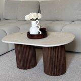 Oval coffee table in travertine and fluted wood.