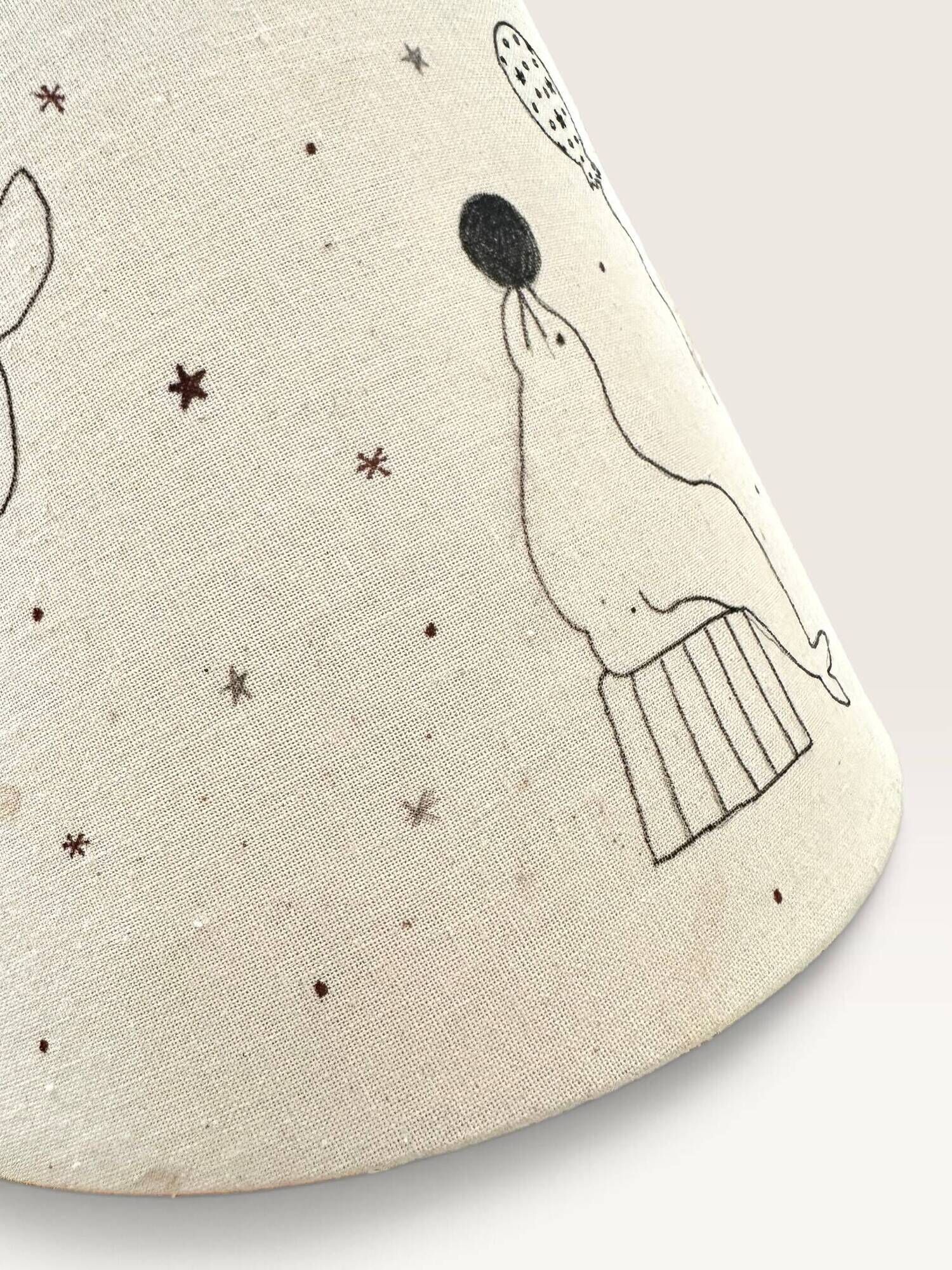 Wood-turned lamp with a hand-drawn lampshade, circus patterns.