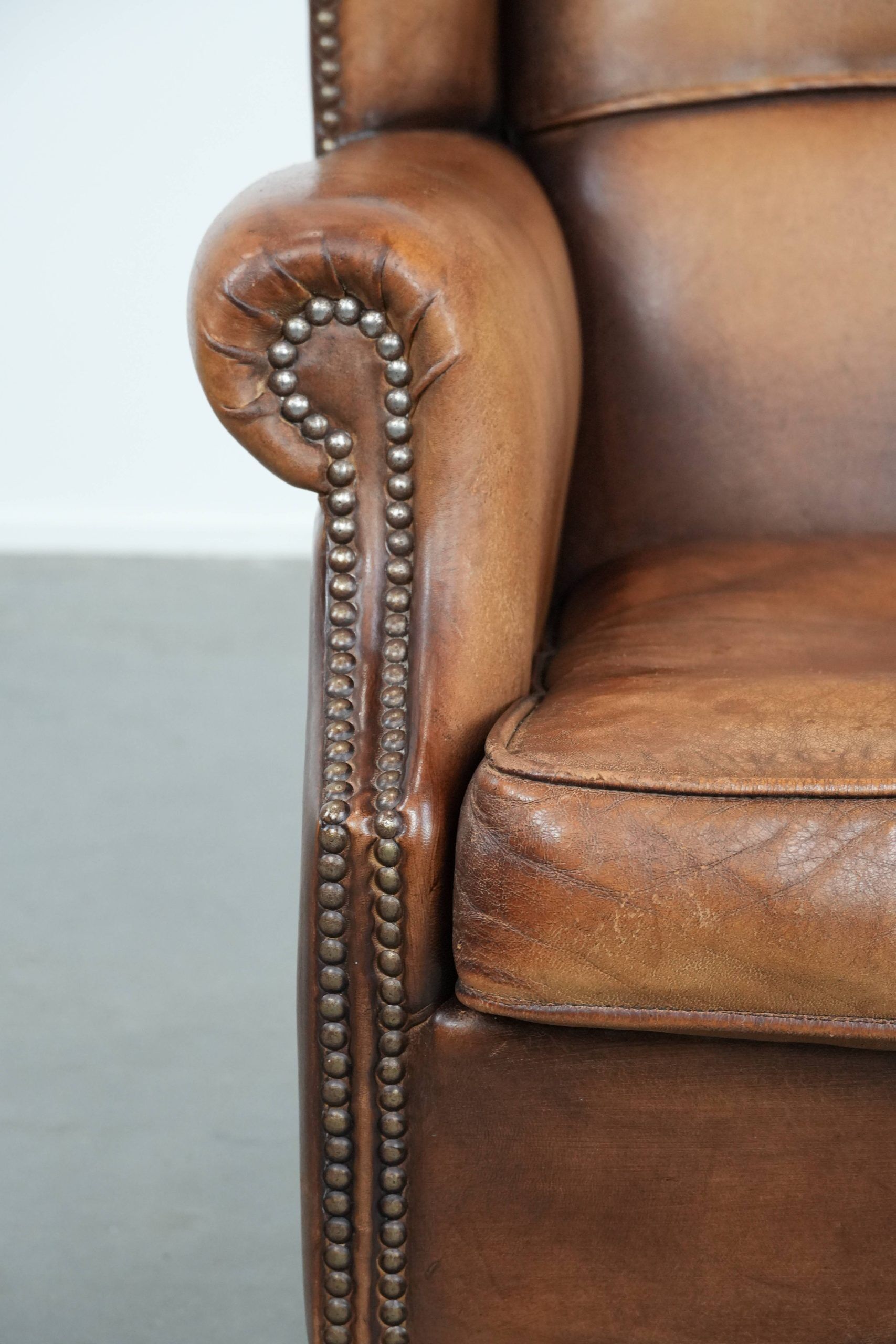 Fauteuil à oreilles en cuir de mouton charmant avec des couleurs chaudes.