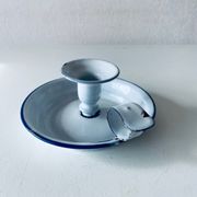 Old candle holder in white enameled metal