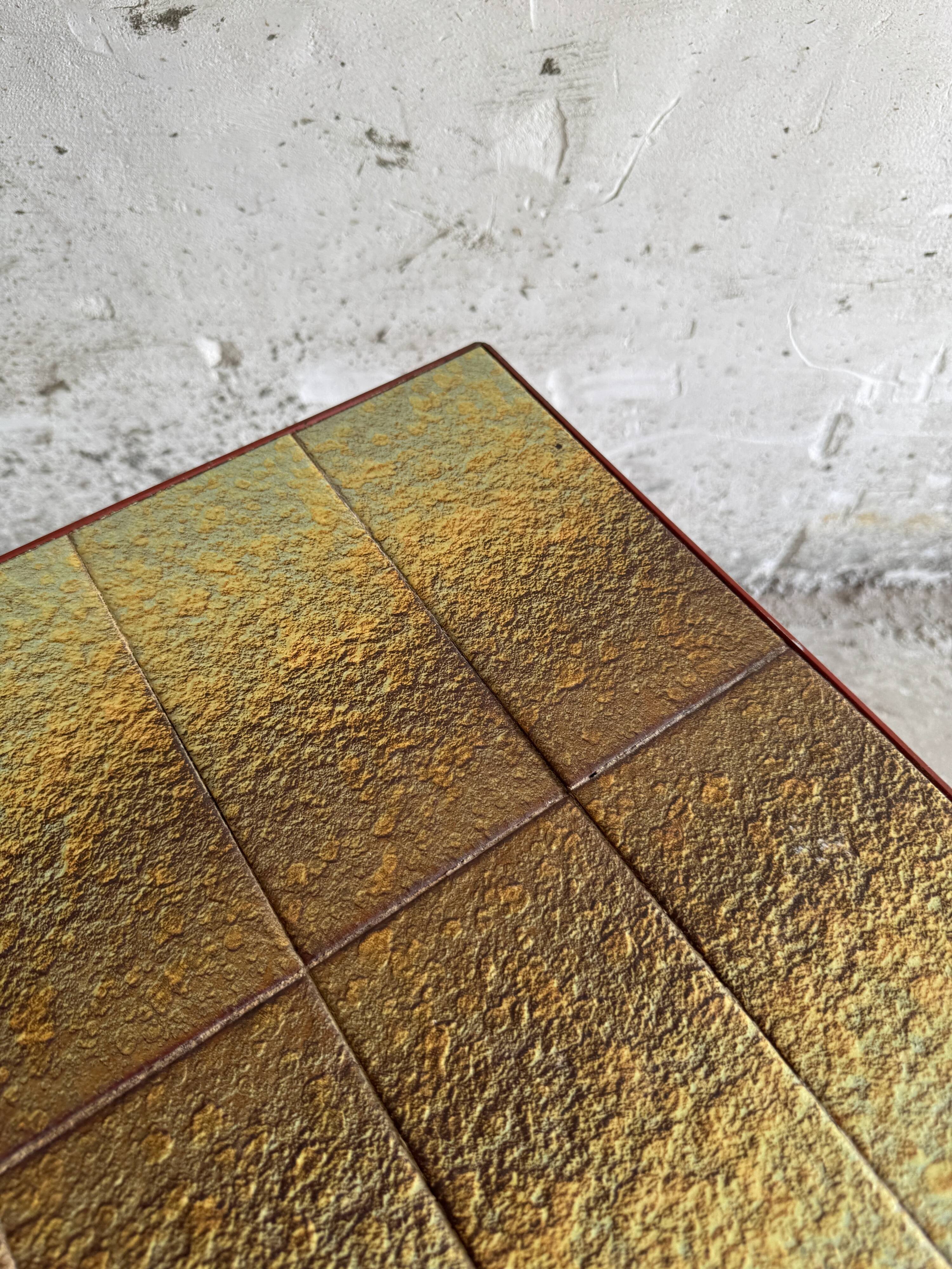 Vintage terracotta-red metal side table with glazed brown-green ceramic tile surfaces