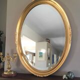 Beveled oval mirror with carved gilded wood frame