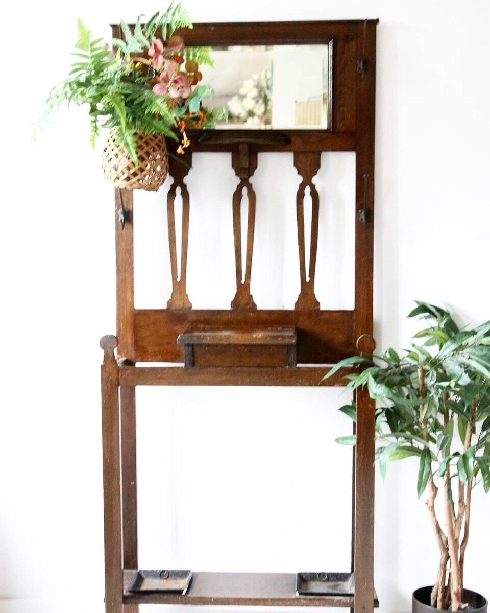 Antique brown wooden coat rack with mirror and umbrella stand, 1900 style.